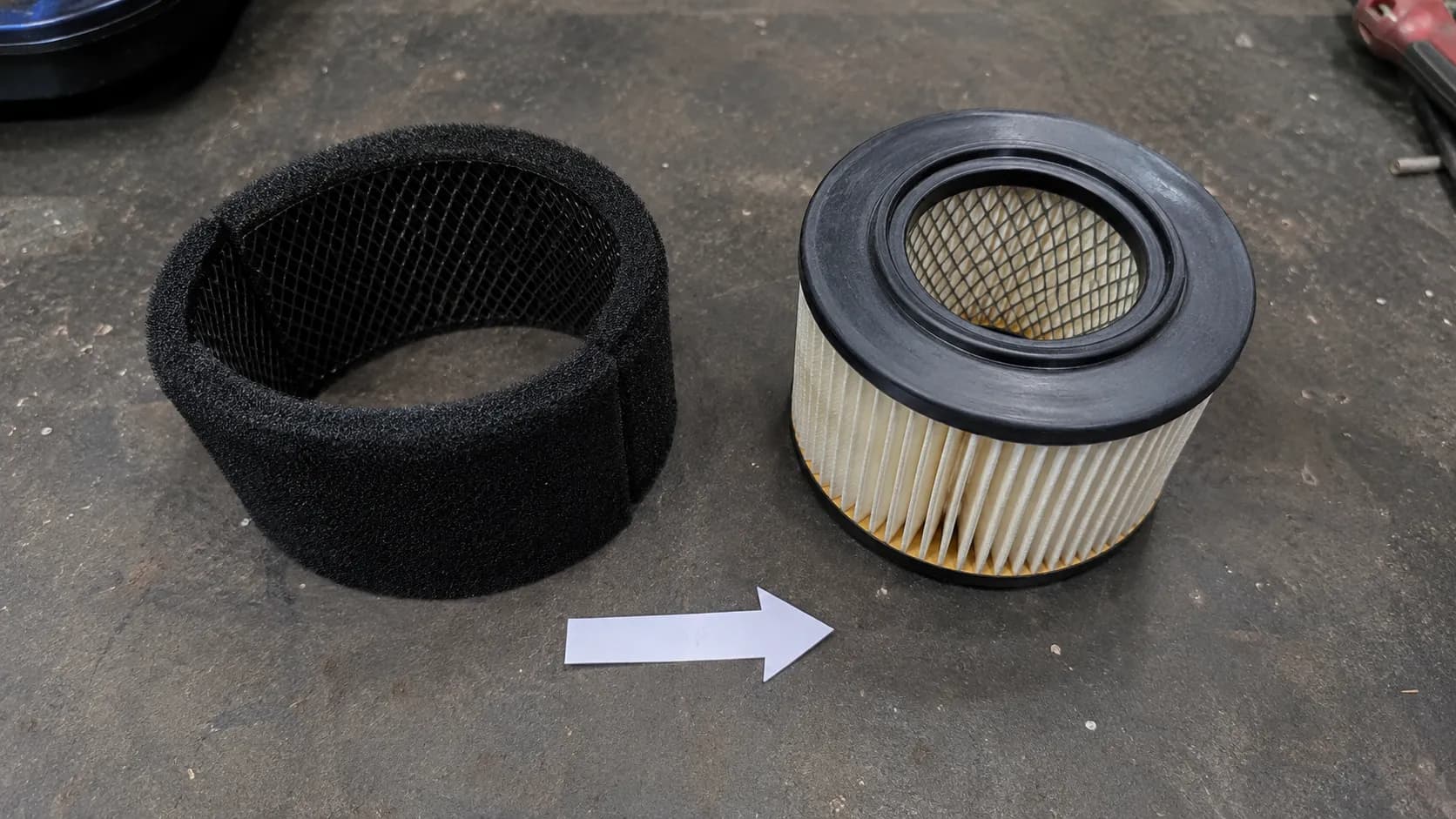 Top-down view of a Briggs & Stratton dual-element air filter showing the foam pre-cleaner and paper cartridge in the correct orientation.