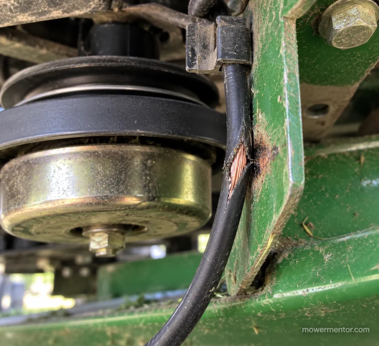 chafed riding mower PTO clutch wire worn to bare copper grounding on a deck bracket