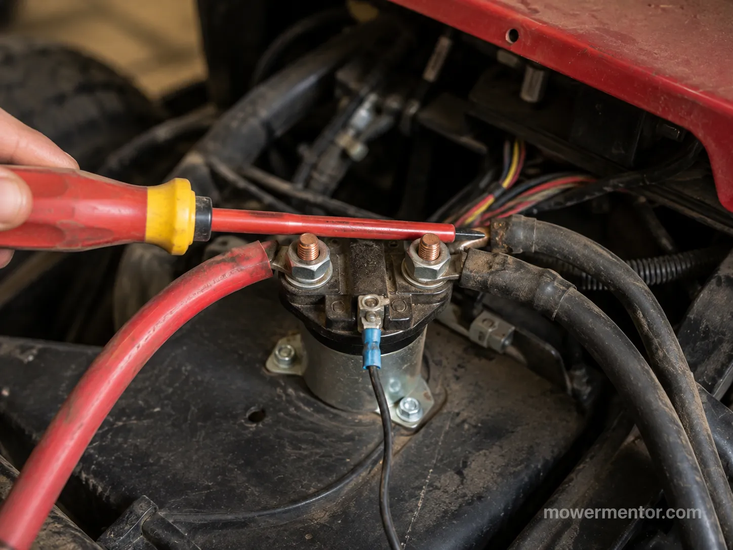 Bridging the two large solenoid posts with a screwdriver to test a Cub Cadet starter solenoid.