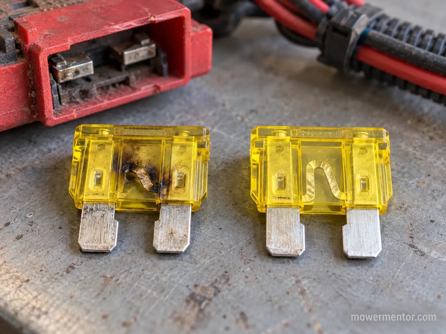 blown 20-amp lawn mower blade fuse with broken element next to a good fuse with intact strip