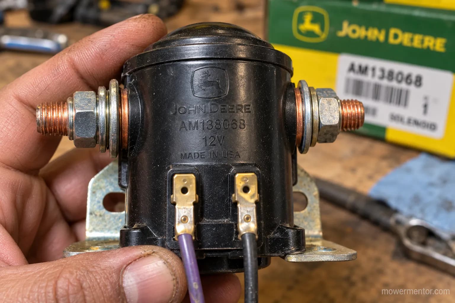 OEM part number stamped on a removed John Deere starter solenoid held in hand.
