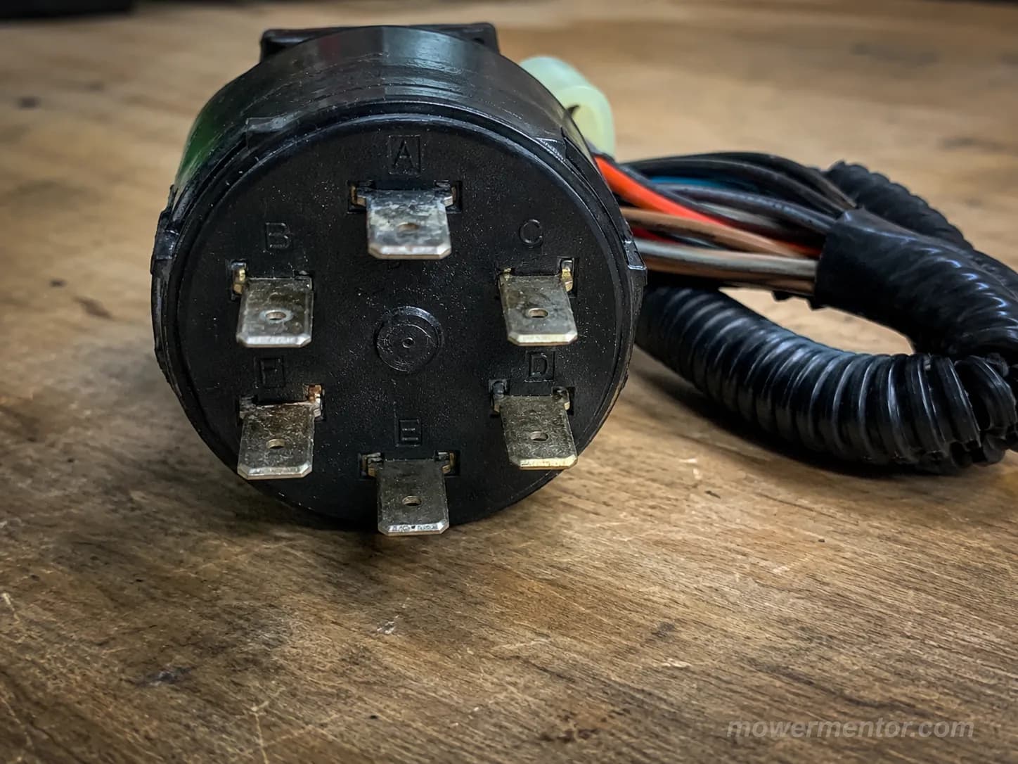 Back of a lawn mower PTO switch showing its lettered terminals.