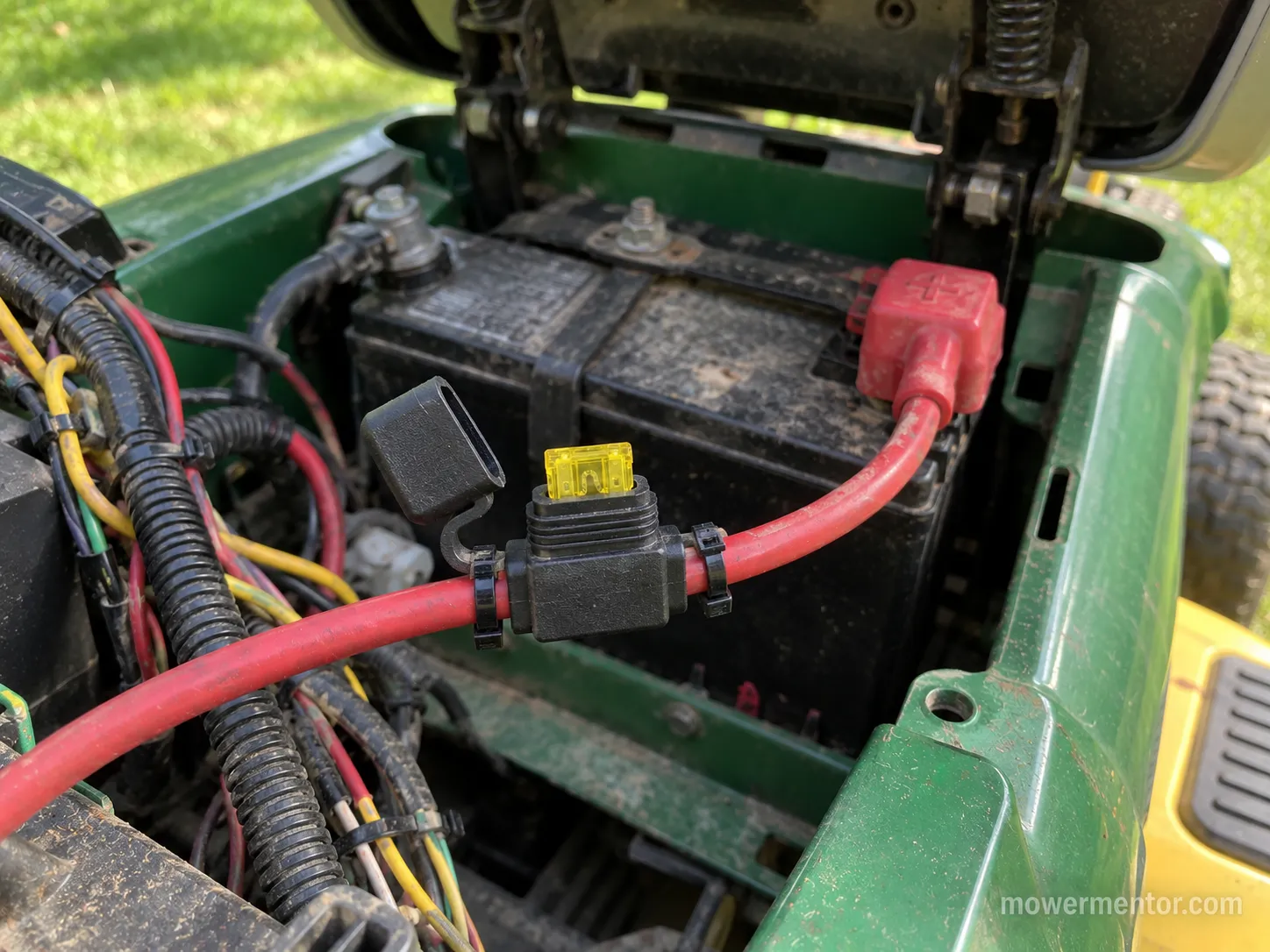 inline fuse holder connected to the red positive battery wire on a riding mower
