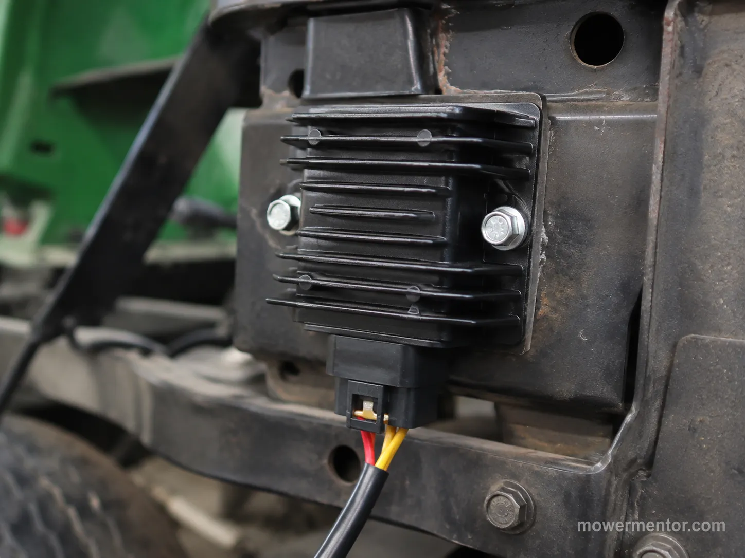 Riding mower voltage regulator rectifier mounted on the frame with its wiring connector
