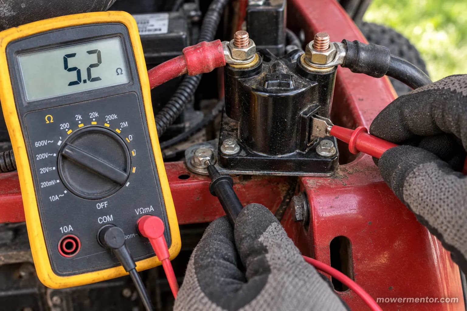 Multimeter reading the coil resistance across a mower starter solenoid S terminal and ground