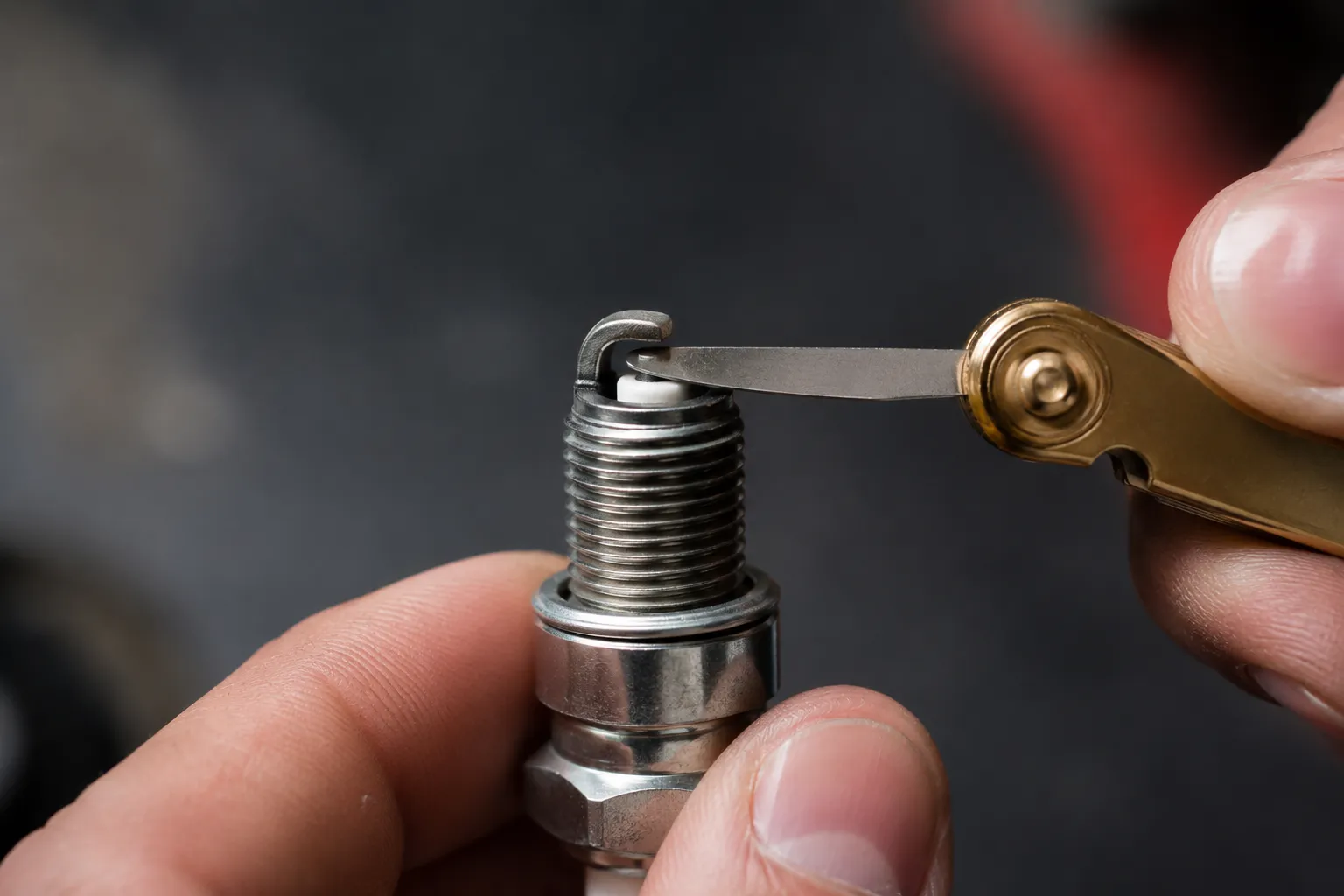 Close-up of a new pre-gapped spark plug being checked with a coin-style feeler gauge to verify the electrode gap before installation in a lawn mower engine.
