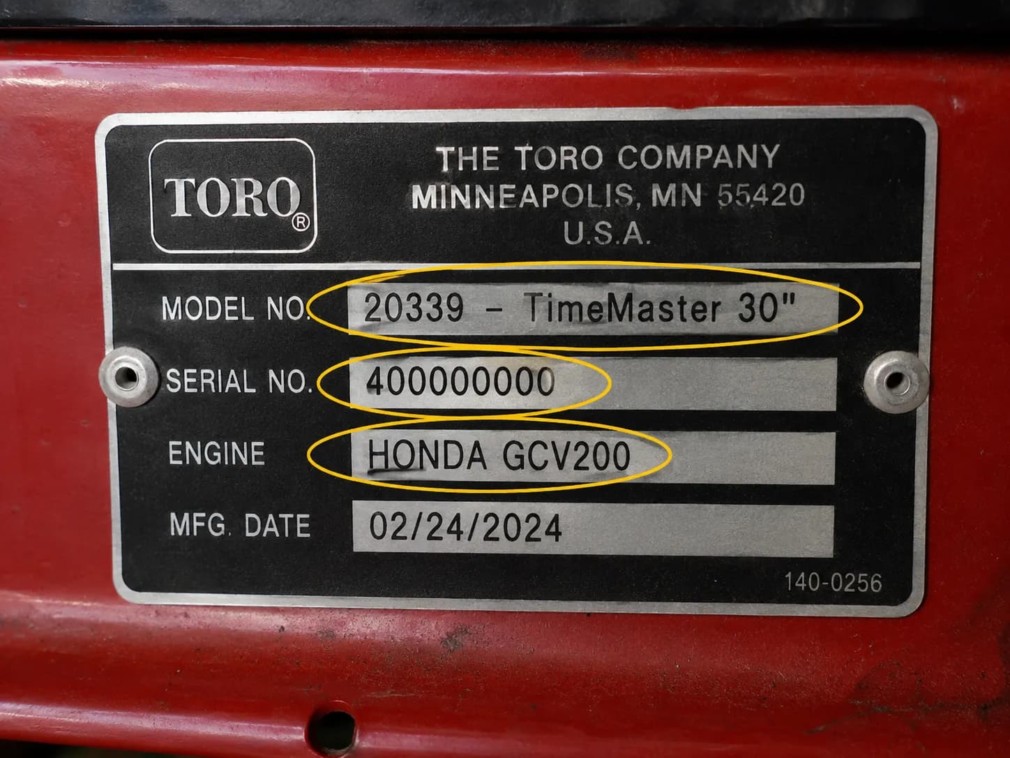 Close-up of a Toro mower deck identification tag with the model number, serial number, and engine information clearly circled for easy reference.