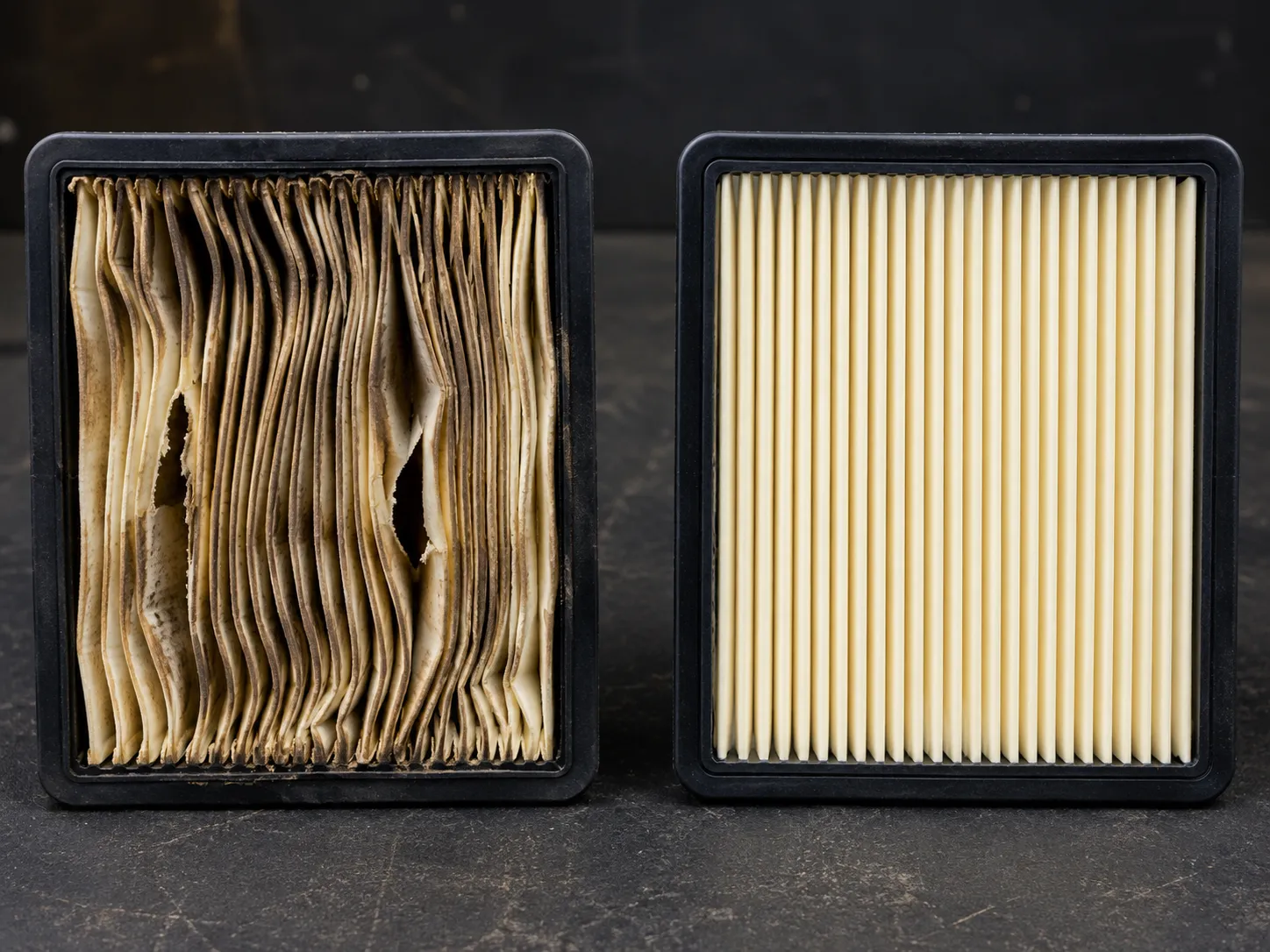 Water-damaged pleated paper air filter with torn, sagging pleats beside an identical new filter showing crisp, evenly spaced pleats for comparison.