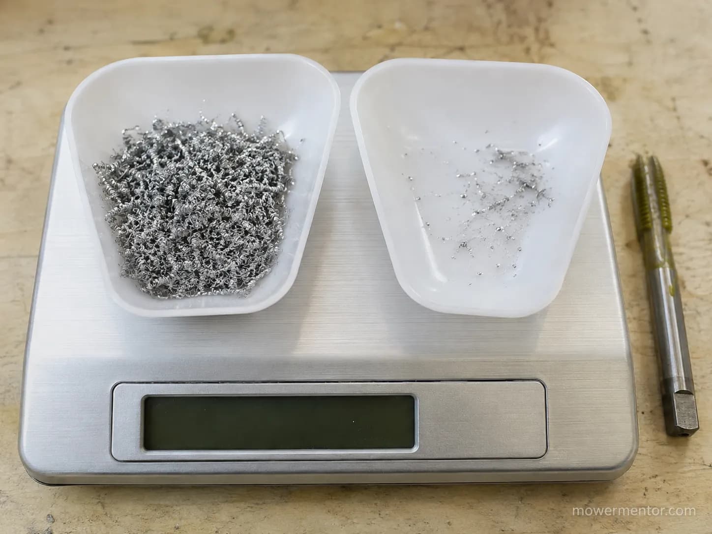 Two weighing boats compare aluminum swarf from dry tapping versus greased, cleared thread cutting, showing far more metal shavings from the dry tap.