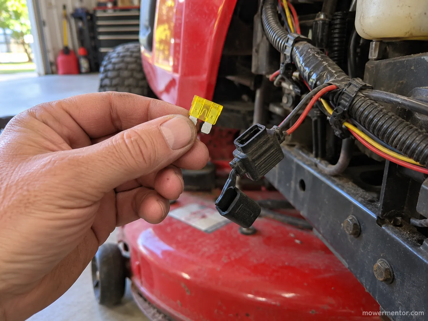 A 20A blade fuse pulled from the inline holder of a Craftsman riding mower wiring harness.