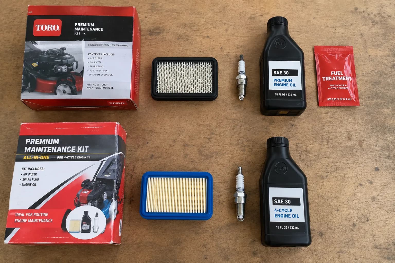 Overhead view of a genuine Toro maintenance kit and an aftermarket kit laid out side by side with matching air filters, spark plugs, oil bottles, and one fuel-treatment packet.