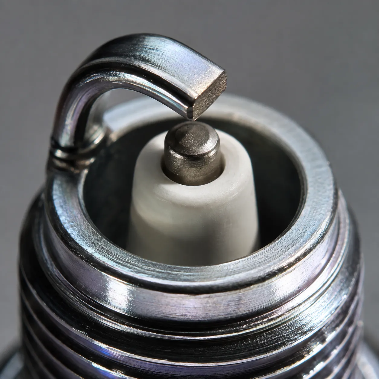 Macro view of a new NGK BPR4ES spark plug showing the ground strap sitting noticeably off centre above the center electrode straight from the box before installation.