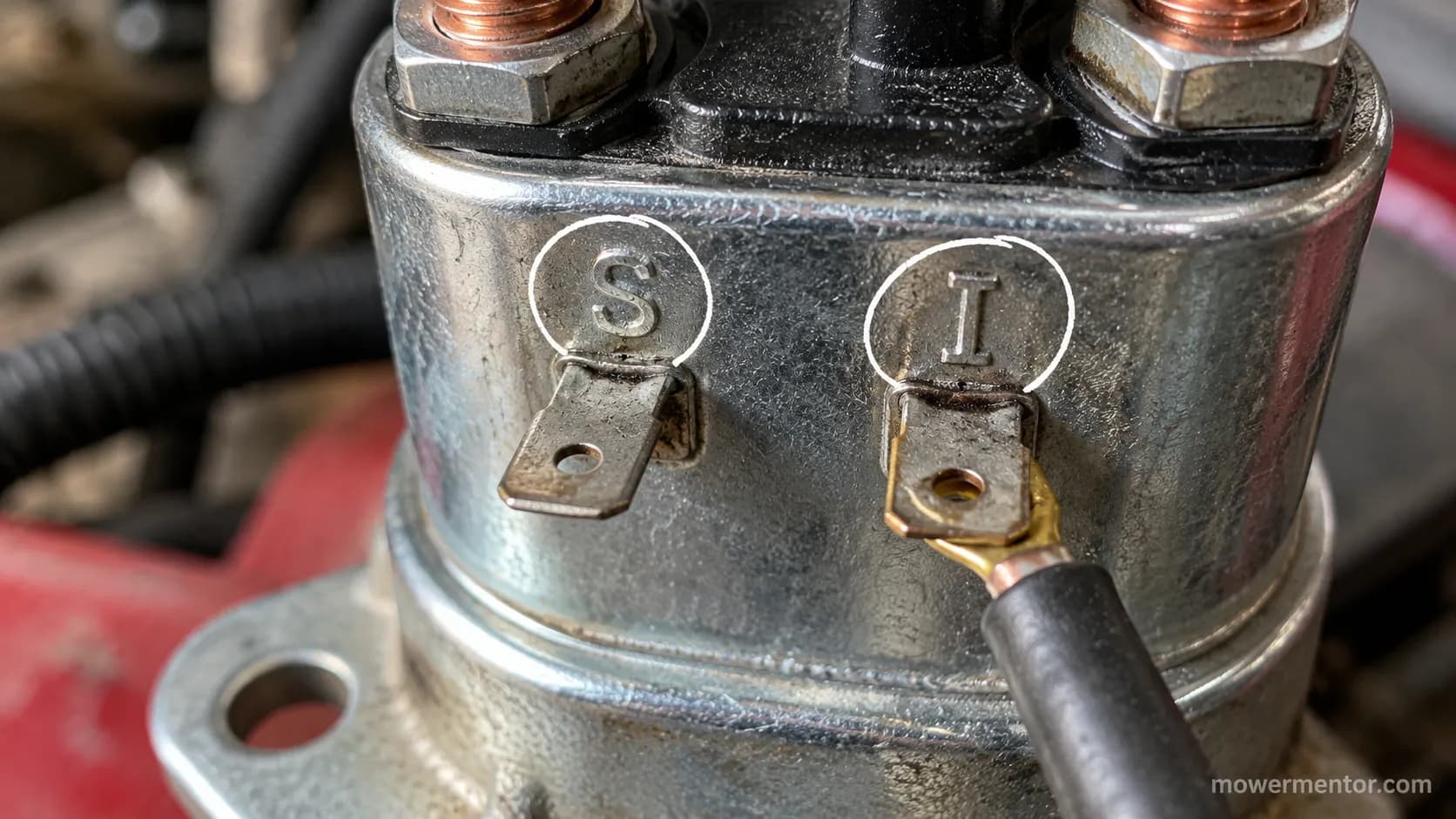 Close-up of lawn mower solenoid small terminals stamped S and I.