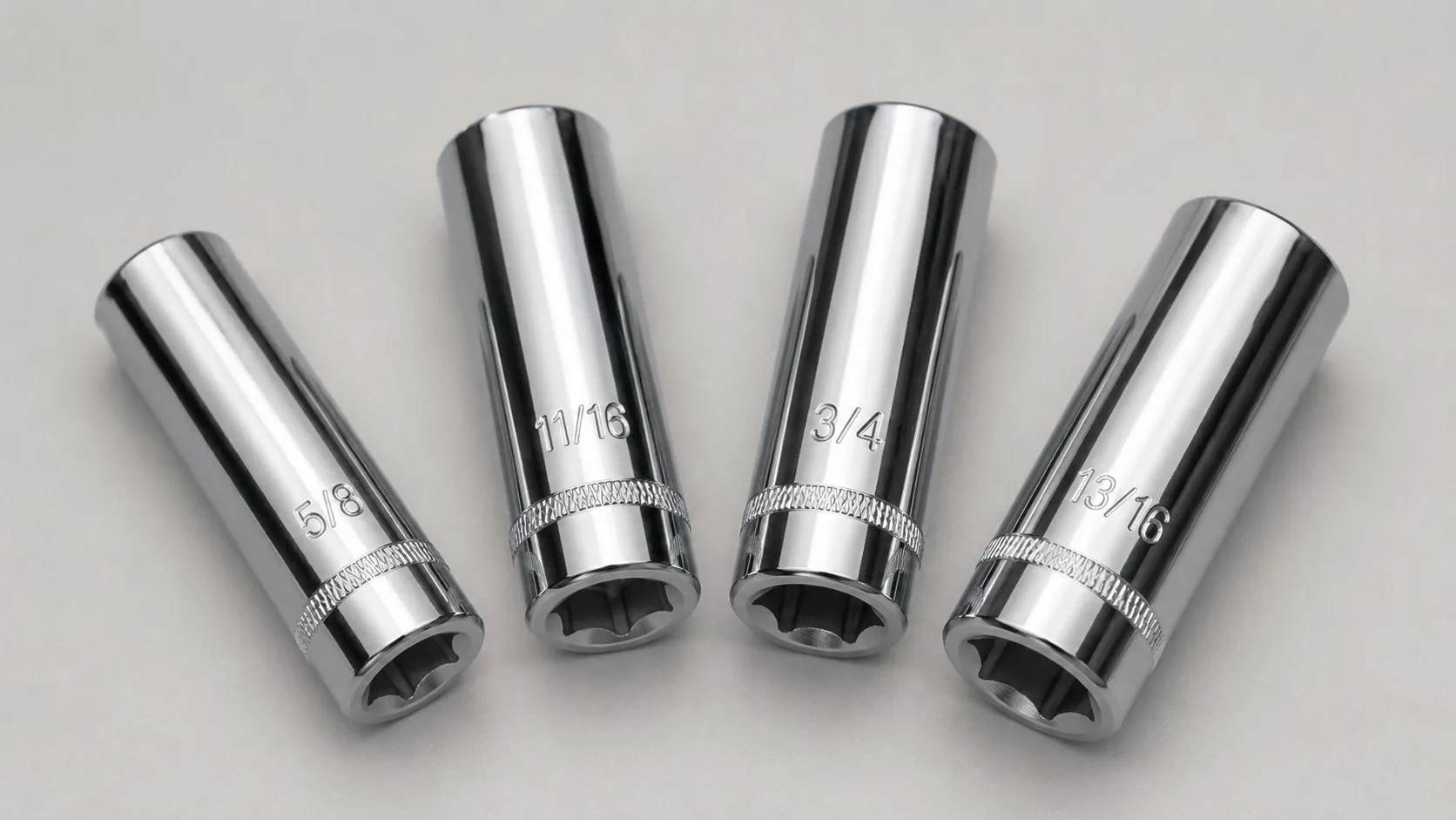 Four chrome spark plug sockets in different sizes, including 5/8-inch and 13/16-inch, arranged for comparison to help choose the correct socket for lawn mower spark plugs.