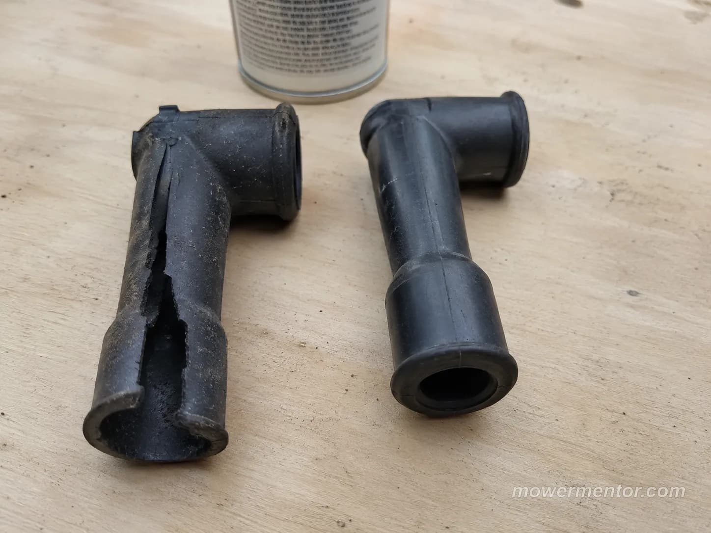Torn black spark plug boot beside an intact boot on a workbench, showing the difference after warming the rubber for easier removal.