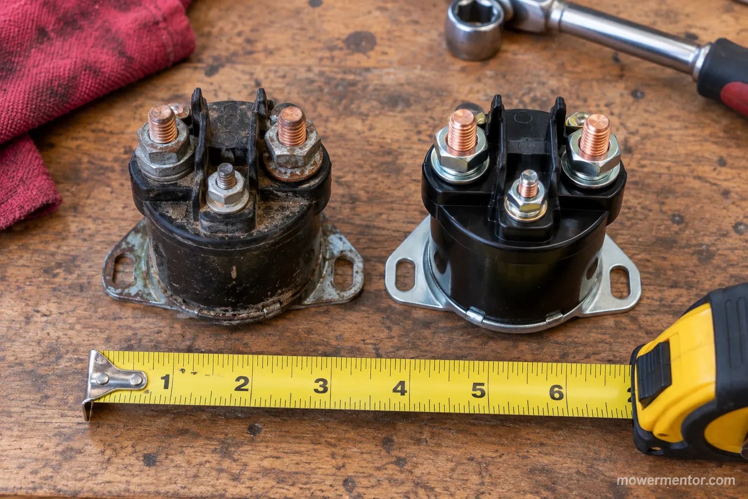 Old and new three-post 725-1426 starter solenoids side by side on a workbench for a Troy-Bilt fitment comparison.